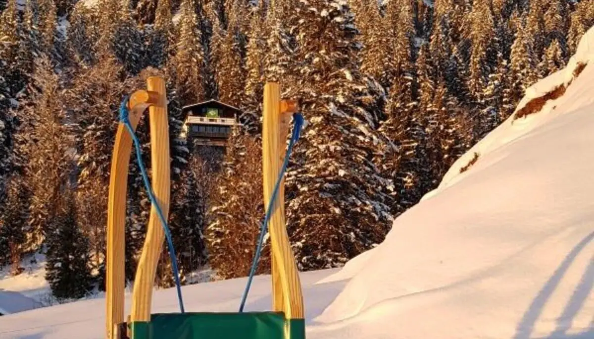 Rodel vor dem Brünnsteinhaus und Brünnstein | © Yvonne Tremml